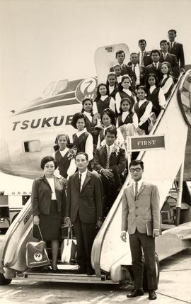 อาจารย์ประสิทธิ์และอาจารย์ลัดดาพร้องทั้งคณะนาฏศิลป์ไทย และนักดนตรีไทย ถ่ายภาพที่บันไดขึ้นเครื่องบ...